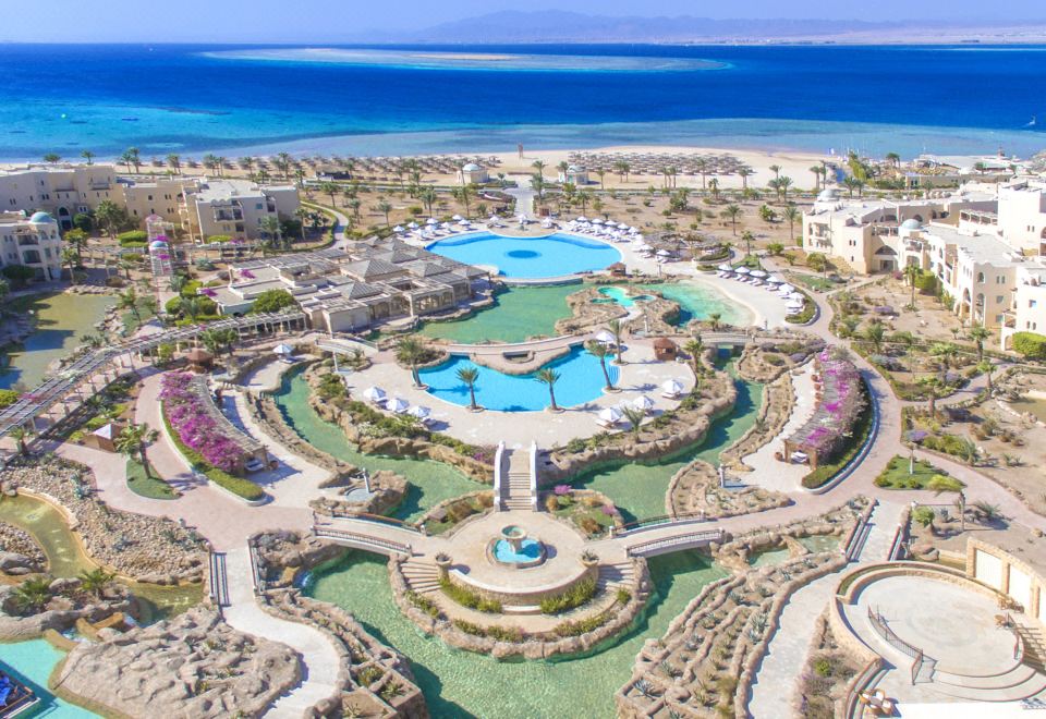 aerial view of a resort with a large pool surrounded by multiple buildings , including a hotel at Kempinski Hotel Soma Bay