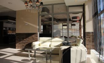 a modern living room with a white couch , a chair , and a chandelier hanging from the ceiling at Park Hotel