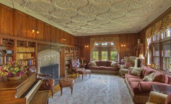 a spacious living room with wooden paneling on the ceiling , a fireplace , and various pieces of furniture at Castle Hill Resort and Spa