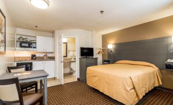 a hotel room with a bed , desk , and kitchenette , all situated in a modern design at Siegel Select Bartlett Extended Stay in Tennessee