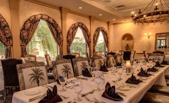 a large dining room with a long table set for a formal dinner , featuring multiple chairs and napkins at Mission Inn Resort & Club