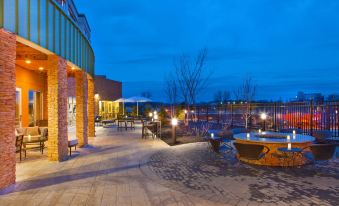 a well - lit courtyard with a hot tub and a pond , surrounded by buildings and lit up at night at Courtyard Yonkers Westchester County