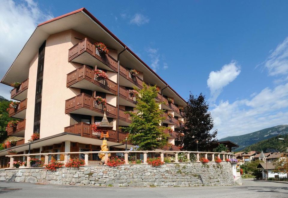 a large apartment building with multiple balconies and flower pots , situated on a hill overlooking a body of water at Miravalle