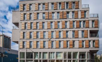 a modern building with multiple windows and wooden shutters , giving it an air of grandeur at Hotel 99