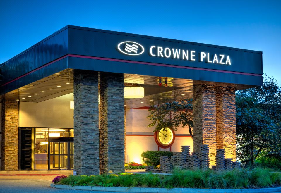 the entrance of a crowne plaza hotel with a large sign and stone columns on either side at Crowne Plaza Suffern-Mahwah, an IHG Hotel