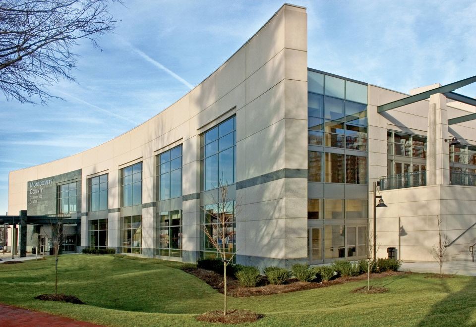a large building with a modern exterior and glass windows is surrounded by greenery and grass at Bethesda North Marriott Hotel & Conference Center