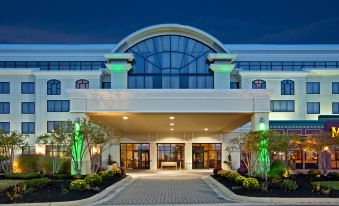 a large hotel entrance with a white building and green lights on top of it at Holiday Inn Wilmington