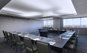 a large conference room with several rows of chairs arranged in a semicircle , facing a long table at The Westin Guadalajara