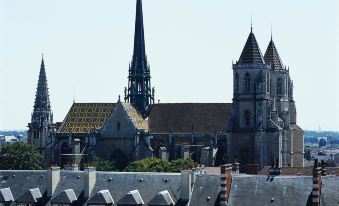 a view of a city with several historic buildings , including the notre - dame cathedral and its bell tower at Grand Hôtel la Cloche Dijon - MGallery