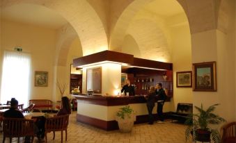 a hotel lobby with a reception desk and several people standing or sitting around the area at Hotel Miramare