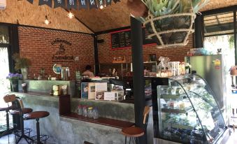 a small coffee shop with a brick wall , a counter , and various items on display at BaanSuanLeelawadee Resort Amphawa