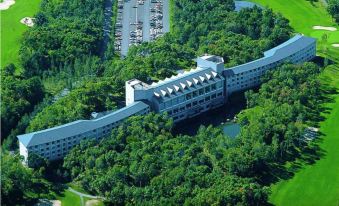 aerial view of a large hotel surrounded by green trees and grass , with cars parked in the parking lot at Hakodate-Onuma Prince Hotel