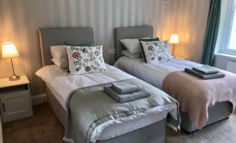 a room with two twin beds , one on the left side and the other on the right side of the room at Golf House