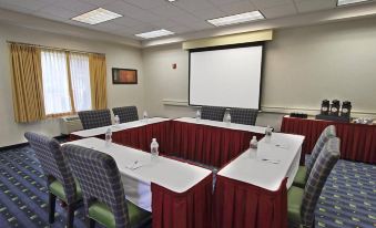 a conference room set up for a meeting , with multiple chairs arranged in a semicircle around a table at Holiday Inn & Suites Bothell
