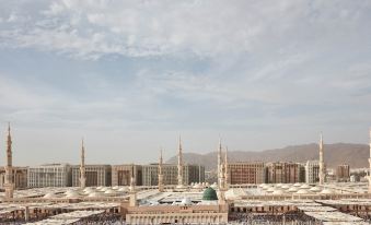 a large crowd of people gathered in a mosque , with many of them standing on the other side of the building at Pullman Zamzam Madina