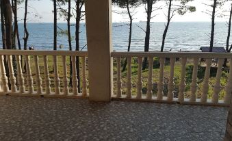 a balcony with a railing , offering a view of the ocean and trees in the distance at Villa Eli