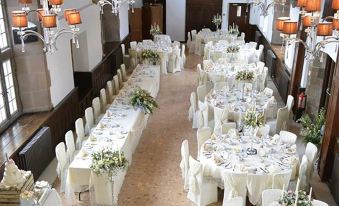 a long dining table set up for a wedding reception , with multiple chairs arranged around it at Risley Hall Hotel