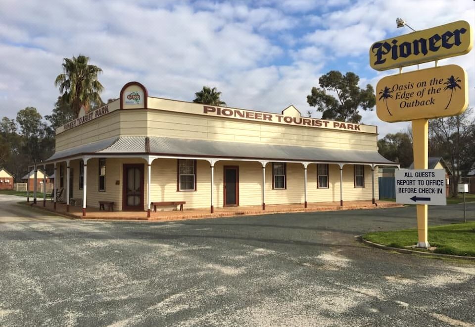 "a building with a sign that reads "" pioneer tourist park "" on the side of the building" at Deniliquin Pioneer Tourist Park