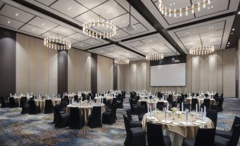 A ballroom is prepared with tables and chairs for an event or formal function at Avani Sukhumvit Bangkok Hotel