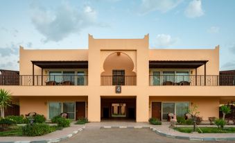 a modern , two - story building with an arched entrance and a staircase leading to the second floor at Jolie Ville Hotel & Spa Kings Island Luxor