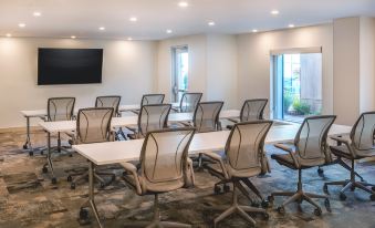 a conference room with white chairs arranged in rows and a television mounted on the wall at Element Chelmsford