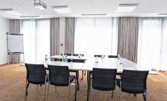 a conference room with a long table , chairs , and water bottles set up for a meeting at Hampton by Hilton Toulouse Airport