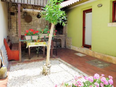 a courtyard with a table and chairs , surrounded by potted plants and flowers , is shown at Ingrid