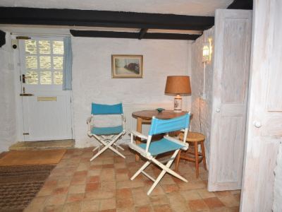 a small dining area with a wooden table and two blue chairs , one of which is a chair at Kim