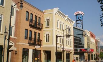 a city street with a row of colorful buildings , including a hotel sign , under a clear blue sky at Best Western Plus Wilkes Barre Center City