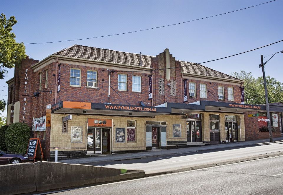 "a brick building with a sign that reads "" new york pizza "" on the side of the building" at Nightcap at Pymble Hotel