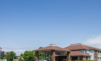 a large , well - maintained parking lot with several cars parked in front of a building , under a clear blue sky at Quality Inn & Suites Newberry