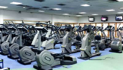 a large room filled with various exercise equipment , including treadmills , elliptical machines , and stationary bikes at Village Hotel Liverpool