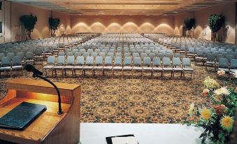 a large conference room with rows of chairs and a podium in the center , ready for an event at Sheraton Philadelphia Downtown