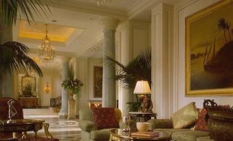 a luxurious living room with a large couch , coffee table , and paintings on the walls at Four Seasons Hotel Cairo at the First Residence