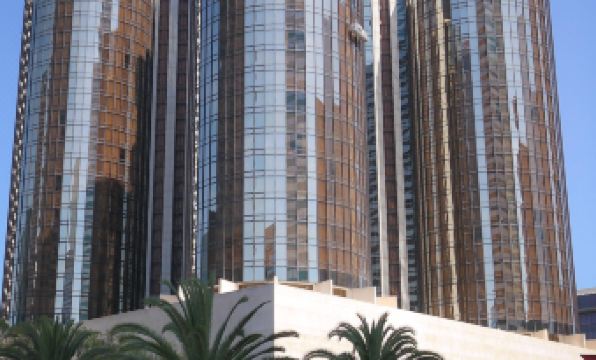 a modern skyscraper with multiple glass towers and a large tree in front of it at The Westin Bonaventure Hotel & Suites, Los Angeles