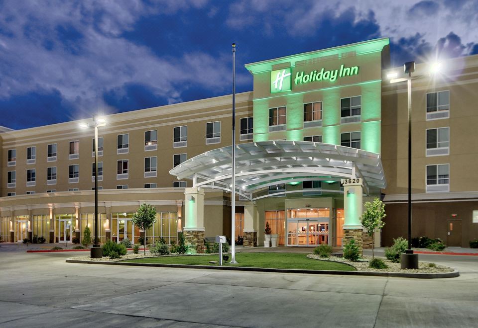 "a large hotel with a green and white sign that says "" holiday inn "" on it" at Holiday Inn Roswell