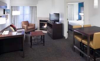 a hotel room with a couch , chairs , television , and a fireplace , along with a dining table and a television at Residence Inn Provo North