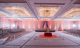 a large banquet hall with multiple levels , decorated with pink and white draping , red rose petals , and a large buddha statue in the center at DoubleTree by Hilton Chicago - Oak Brook
