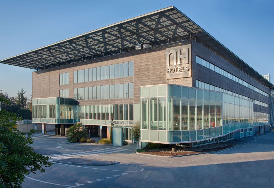"a large , modern building with a glass roof and the letters "" ua "" on its side" at NH Orio Al Serio