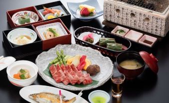 a dining table set with a variety of japanese food , including sushi , salmon , and other dishes at Harataki