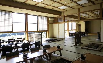 a large room with multiple tables and chairs arranged in rows , possibly for a dining experience at Ryokan Warabino