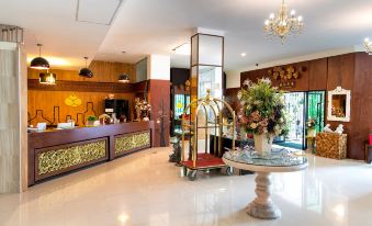 a hotel lobby with a reception desk , potted plants , and a chandelier hanging from the ceiling at Soho Boutique Hotel