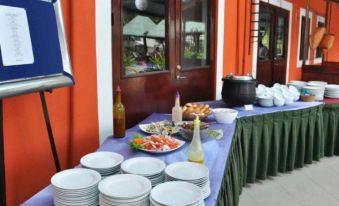 There is an outdoor buffet-style dining room with a table containing plates and bowls at Laya Leisure Kukuleganga