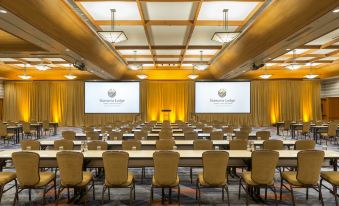 a large conference room with multiple rows of chairs arranged in a semicircle , and two televisions mounted on the wall at Skamania Lodge