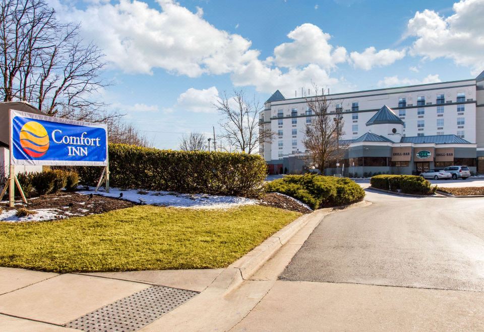 a hotel with a blue sign in front of it and a driveway leading up to it at Comfort Inn Largo-Washington DC East