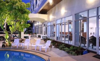 a modern building with large windows and outdoor seating area , possibly a pool or terrace at The Great Rayong Hotel