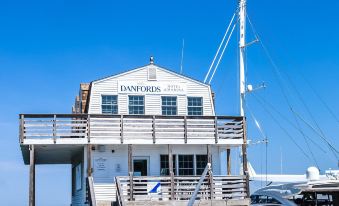 "a white house with the word "" da river "" on it is docked at a pier , surrounded by boats" at Danfords Hotel & Marina