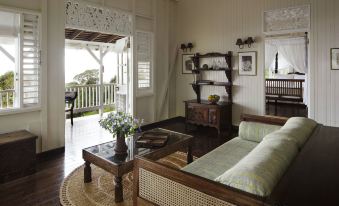 a living room with a couch , coffee table , and potted plant is shown with a view of the balcony at Strawberry Hill