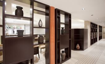 a modern office space with black shelving units filled with various items , including vases and potted plants at Hotel Nord