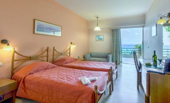 a hotel room with two beds , one on the left and one on the right side of the room at Golden Sand Hotel